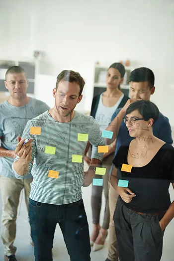 Teilnehmende arbeiten in Gruppen an Design-Thinking-Übungen im Workshop