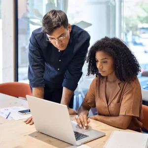 Trainer gibt Teilnehmerin individuelles Feedback am Laptop während der Webdesign Fundamentals Weiterbildung der UIX Academy